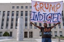 Протестующая с плакатом "Трамп обвинен" у здания федерального суда в Вашингтоне. 1 августа 2023 года
