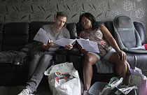 Sadie James, a la derecha, y Jon Taylor, gestor de deudas de la organización benéfica Cristianos contra la Pobreza, leen los documentos de una asociación de la vivienda en su casa, en Londres, 2023.