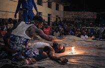A voodoo wrestler whispers incantations over his opponent during a fight in a schoolyard in Selemenbao district in Kinshasa, on July 29, 2023.