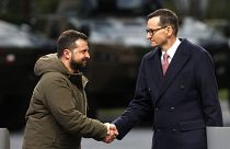 Mateusz Morawiecki lengyel miniszterelnök kezet fog Volodimir Zelenszkij ukrán elnökkel közös varsói sajtótájékoztatójukon. 2023. április 5-én