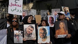 أقارب ضحايا الانفجار الدامي في مرفأ بيروت يحملون صوراً لأحبائهم خلال مظاهرة أمام قصر العدل في بيروت، لبنان، الخميس 26 يناير 2023.