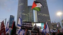 متظاهرون يلوحون بالعلمين الفلسطيني والإسرائيلي في تل أبيب