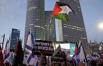 متظاهرون يلوحون بالعلمين الفلسطيني والإسرائيلي في تل أبيب 