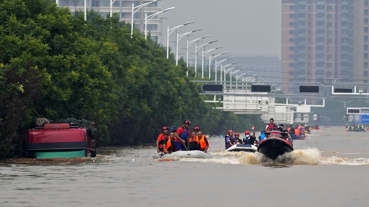 Equipas de salvamento utilizam barcos para evacuar residentes, numa cidade próxima de Pequim, na China.