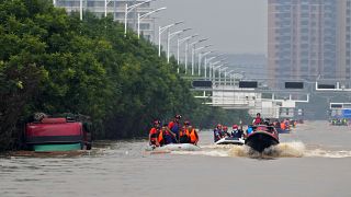 Equipas de salvamento utilizam barcos para evacuar residentes, numa cidade próxima de Pequim, na China.