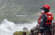 Oficial da guarda costeira observa as ondas antes da passagem do tufão Khanun, no norte de Taiwan, esta quinta-feira.