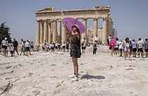Szelfiző turista az Akropolisz-hegy tetején álló Parthenon templom előtt Athénban, Görögországban, 2023. július 21-én