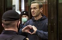 Алексей Навальный делает жест сердечком, стоя за решёткой во время слушаний в Москве, Россия, 3 февраля 2021 года.
