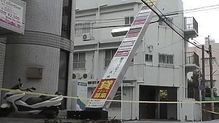 This image made from video provided by NTV shows tilted shop sign, following Typhoon Khanun, in Naha, Okinawa prefecture, Aug. 3, 2023.