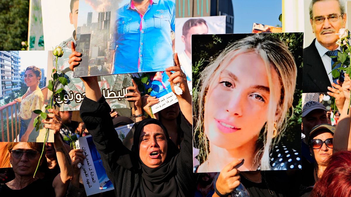 Relatives of victims of the deadly 2020 Beirut port explosion react as they hold portraits of loved ones to mark the third anniversary of the massive blast