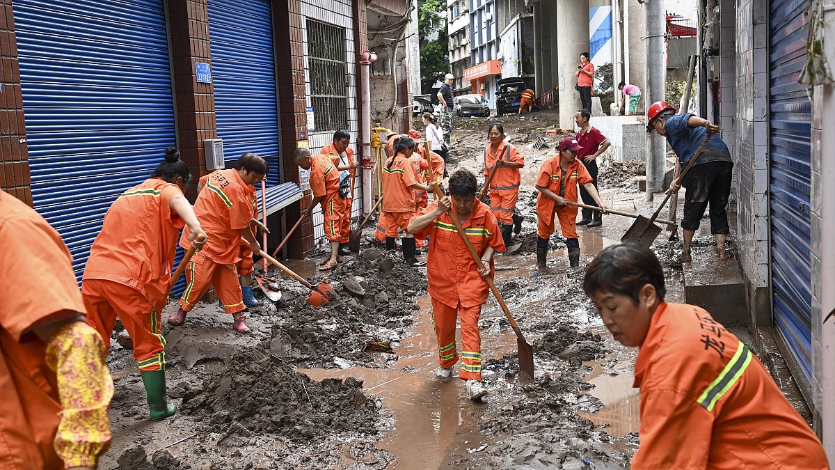 عمال يقومون بتنظيف الشوارع بعد فيضان في منطقة وانزهو في تشونغتشينغ، الصين