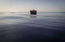 Мигранты, пересекающие Эгейское море на надувной лодке.