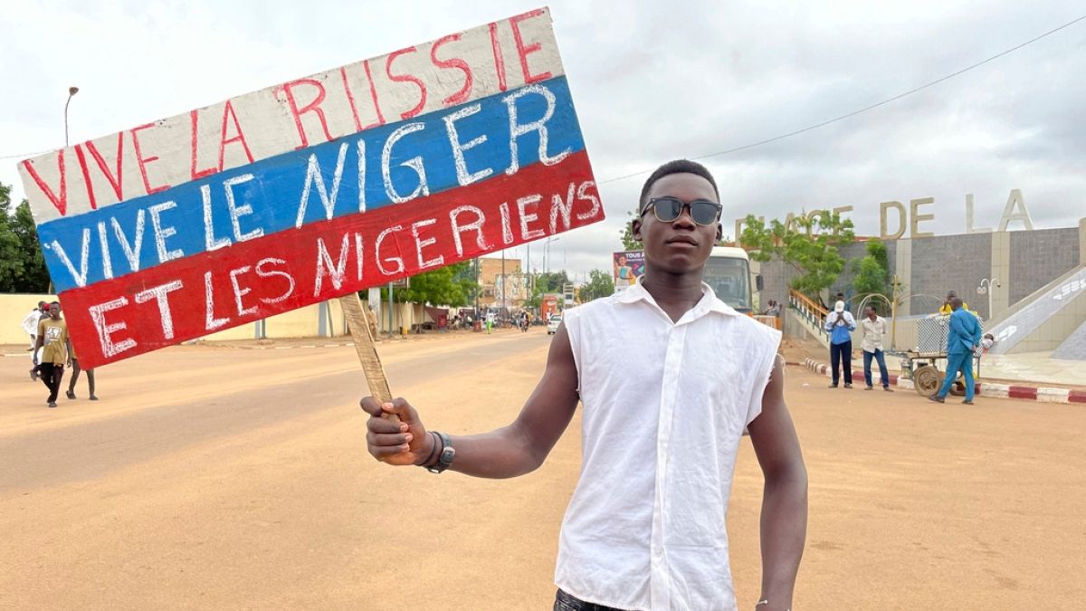 Nijer'de darbe sonrası "Yaşasın Rusya, Yaşasın Nijer, Yaşasın Nijerliler" yazılı pankart taşıyan bir genç