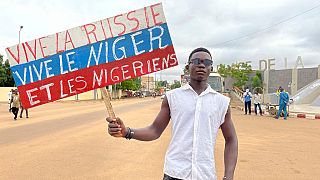 Nijer'de darbe sonrası "Yaşasın Rusya, Yaşasın Nijer, Yaşasın Nijerliler" yazılı pankart taşıyan bir genç
