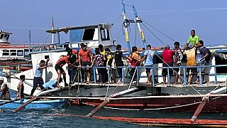 Des sauveteurs aident les passagers après qu'un ferry pour passagers a commencé à prendre de l'eau au centre des Philippines, le samedi 5 août 2023.