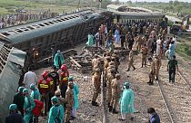 Paramilitares e voluntários inspeccionam as carruagens no local do acidente após descarrilamento de comboio de passageiros em Nawabshah, em 6 de agosto de 2023