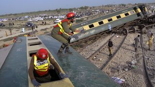 Rettungskräfte klettern in den entgleisten Zug herein
