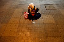 A woman holds her child to beg for money near Taksim Square in, Istanbul, Turkey, Tuesday, June 18, 2013.