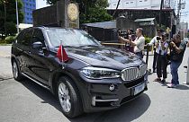 Journalists take pictures of a car with diplomatic plates and Chinese flag leaves the Philippine Department of Foreign Affairs in Manila, Philippines on Monday, Aug. 7, 2023.
