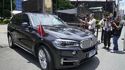 Journalists take pictures of a car with diplomatic plates and Chinese flag leaves the Philippine Department of Foreign Affairs in Manila, Philippines on Monday, Aug. 7, 2023. 