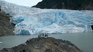 A group of people take in the views of the Mendenhall Glacier on June 8, 2023, in Juneau, Alaska.