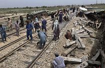 Des ouvriers réparent une voie ferrée sur le site de l'incident du train qui a déraillé dimanche, près de Nawabshah, un district de la province du Sindh, dans le sud du Pakist