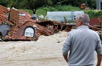 Un uomo osserva una casa danneggiata dalle inondazioni a Prevalje, in Slovenia, il 6 agosto 2023.