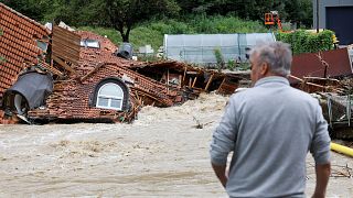 Un hombre observa una casa dañada durante las inundaciones en Prevalje, Eslovenia, el 6 de agosto de 2023.