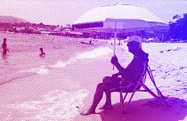 A man sits under the shade of a parasol on the Ricanto beach in Ajaccio, July 2023