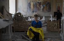 Un giovane mette al sicuro i paramenti della Cattedrale di Odessa