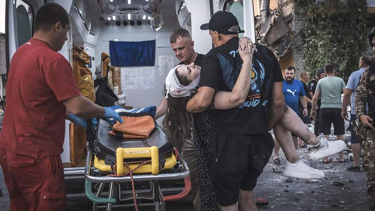 Helfer tragen eine Verletzte aus einem zerstörten Gebäude in Pokrowsk.