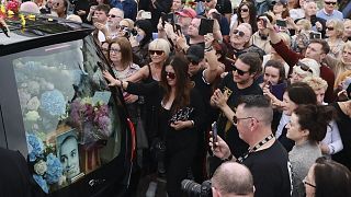 Fans of Sinead O'Connor line the street as her funeral cortege passes through her former hometown of Bray, Co Wicklow, Ireland, Tuesday, Aug. 8, 2023.