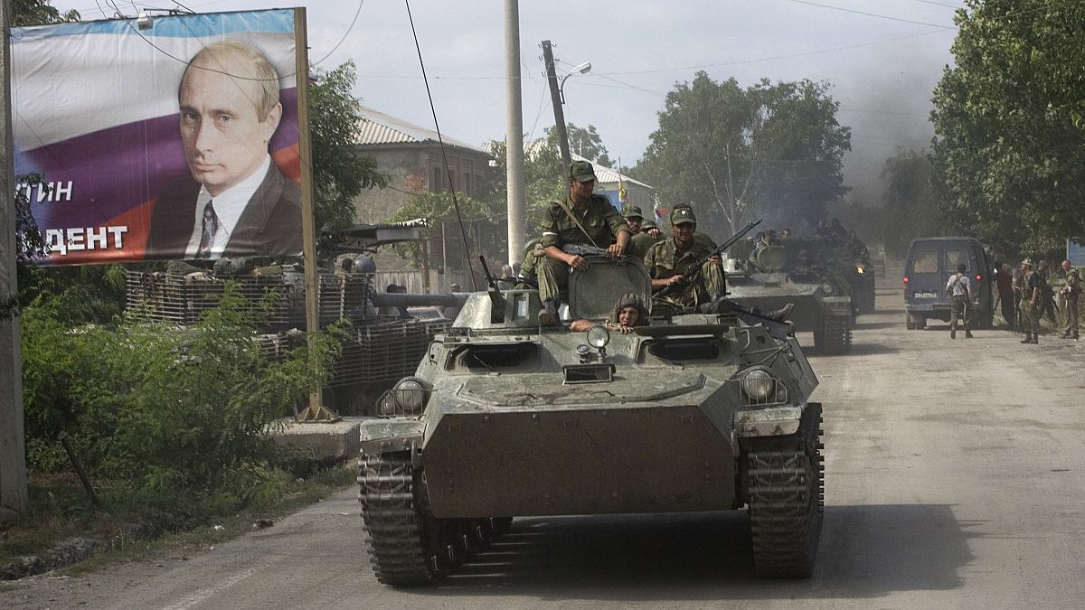 قوات انفصالية في عاصمة أبخازيا عام 2008 وبجانبها ملصق لرئيس الوزراء آنذاك فلاديمير بوتين 