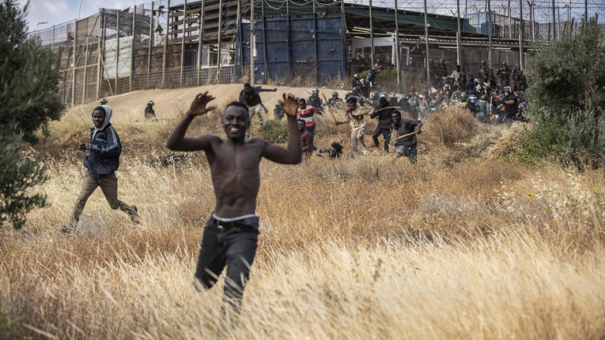 Migranti corrono sul suolo spagnolo dopo aver attraversato le recinzioni che separano l'enclave spagnola di Melilla dal Marocco a Melilla.