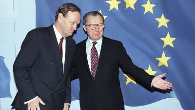 ARCHIVO - El presidente de la Comisión de la Unión Europea, Jacques Delors, a la derecha, muestra el camino al primer ministro canadiense, Jean Chretien, 11 de enero de 1994.