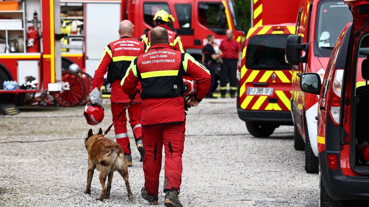 Firefighters and sniffer dogs arrive at the site of a fire which erupted at a home for disabled people in Wintzenheim near Colmar, eastern France.