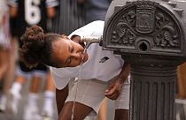 Ein Mädchen in Madrid erfrischt sich an einem öffentlichen Brunnen.
