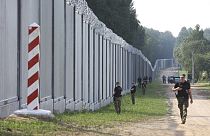 FILE - Polish border guards patrol the area of a newly built metal wall on the border between Poland and Belarus, near Kuznice, Poland, on June 30, 2022.