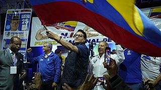 Presidential candidate Fernando Villavicencio waves an Ecuador national flag during a campaign event at a school minutes before he was shot to death outside the same school.