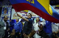 Fernando Villavicencio agita bandeira do Equador durante evento da sua campanha presidencial numa escola, minutos antes de ser morto a tiro, esta quarta-feira.