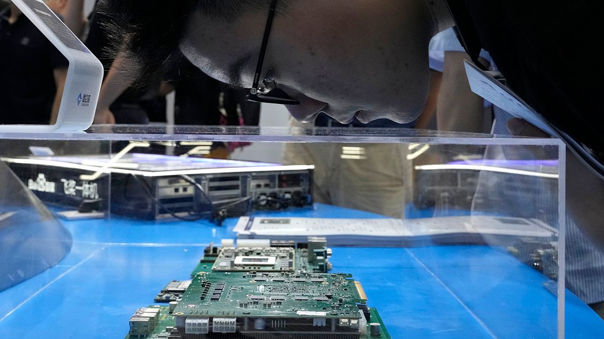 زائر ينظر إلى شرائح الكمبيوتر وأشباه الموصلات الصينية خلال المؤتمر العالمي للذكاء الاصطناعي في شنغهاي