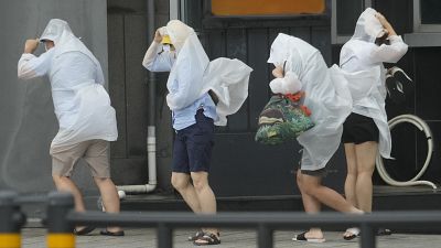 سكان في مدينة بوسان بكوريا الجنوبية يقاومون الرياح العاتية بعد وصول إعصار خانون