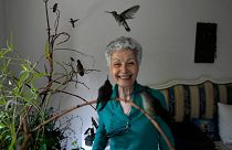 Catia Lattouf poses for a photo with hummingbirds in her care, in her apartment that she has turned into a makeshift clinic for the tiny birds in Mexico City.