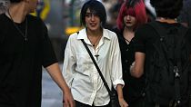 İran'ın başkenti Tahran'da başörtüsü yasağına rağmen, bu kurala uymadan yürüyen genç kadınlar 