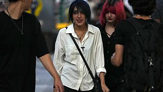 İran'ın başkenti Tahran'da başörtüsü yasağına rağmen, bu kurala uymadan yürüyen genç kadınlar