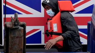 A man thought to be a migrant who made the crossing from France disembarks after being picked up in the Channel by a British border force vessel in Dover, south east England.