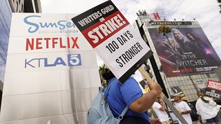 متظاهر يحمل لافتة خارج استوديوهات نيتفلكس خلال إضراب عاملي هوليوود 