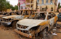 Kiégett autóroncsok a hatalmától megfosztott elnök pártjának niameyi székháza előtt 2023. augusztus 11-én