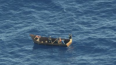 n this photo provided by Sea-Watch on Tuesday, Aug. 8, 2023, four migrant survivors wave for help as they are in distress at sea. 