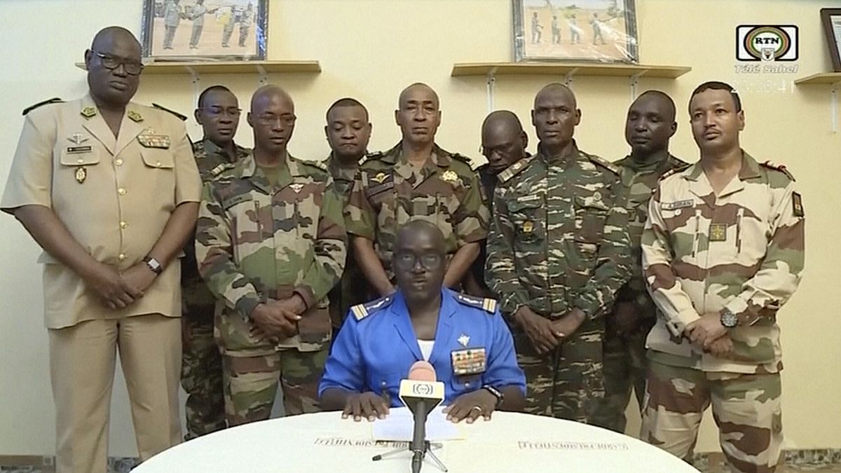 طوق. الرائد. أمادو عبد الرحمن، وسط الجبهة، يدلي ببيان في و 26 يوليو 2023، في نيامي، النيجر، حيث ظهر وفد من ضباط الجيش على تلفزيون النيجر الحكومي.